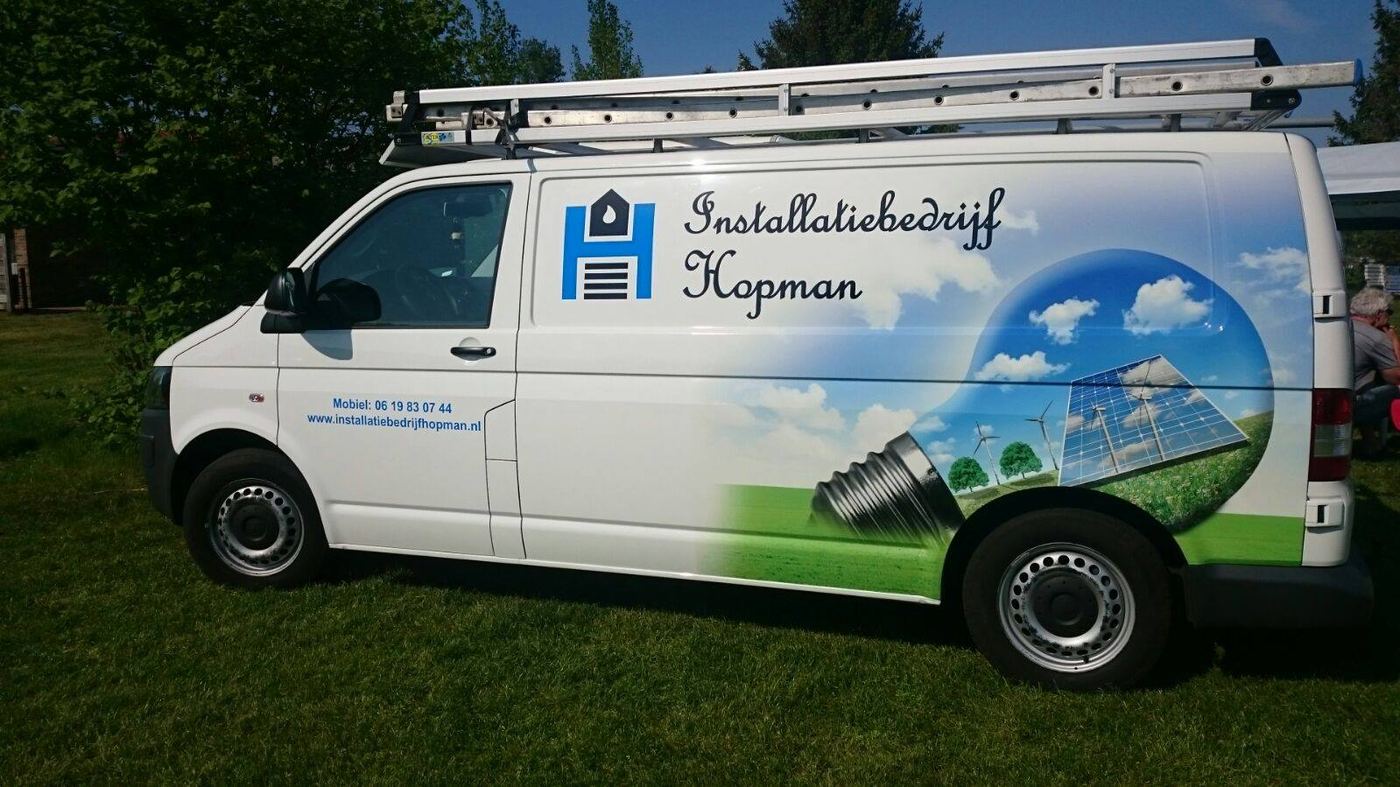 De bedrijfsbus van Installatiebedrijf Hopman met logo en telefoonnummer op de zijkant